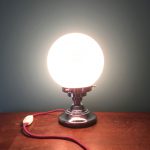 Lampe art déco globe opaline allumée