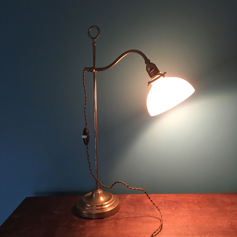 Ancienne lampe laiton avec coupole opaline allumée